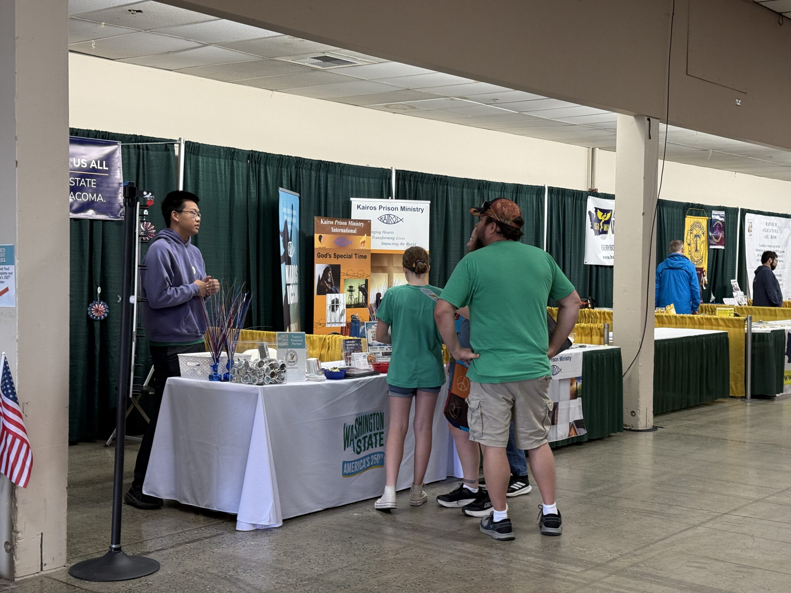 A Youth for History volunteer speaks with visitors at the Washington history booth.