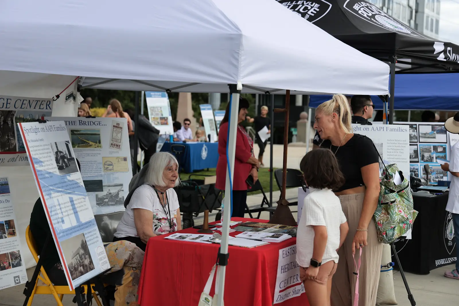 Visitors talking with an Eastside Heritage Center representative beside historical displays